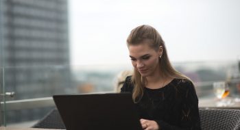 Young adult woman using laptop and smartphone