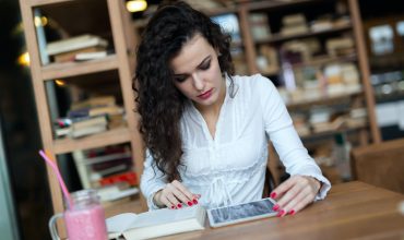 Young woman using digital tablet in coffee shop Young woman using digital tablet in coffee shop
